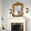Decorative antique gold mirror with detailed frame for timeless interiors.