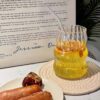 Transparent ribbed glass cup with vintage theme, dishwasher-safe drinkware for modern dining.