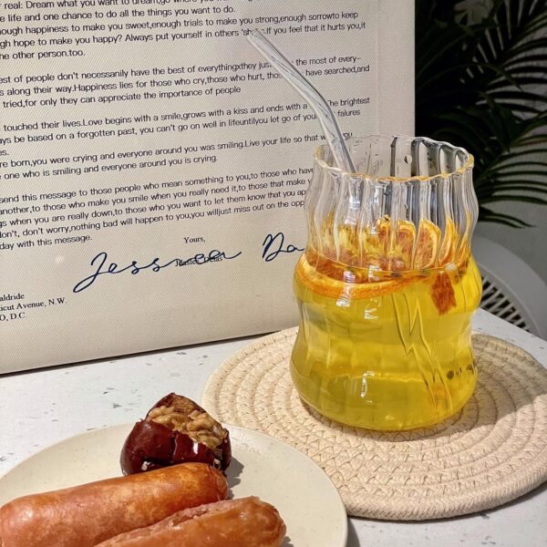 Transparent ribbed glass cup with vintage theme, dishwasher-safe drinkware for modern dining.
