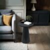 Elegant round pedestal side table with tapered base, adding sophistication to modern interiors.