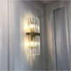 Modern crystal wall sconce with sparkling crystal drops and golden finish for elegant home decor.